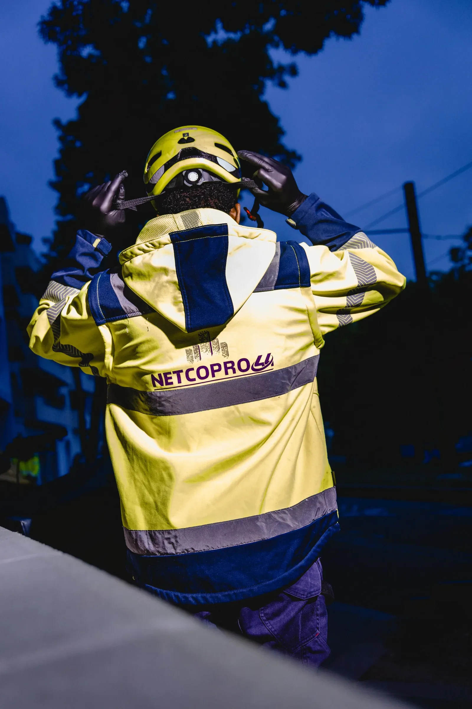 Agent Netcopro44 en veste haute visibilité ajustant son casque à l’aube, avant sa journée de travail